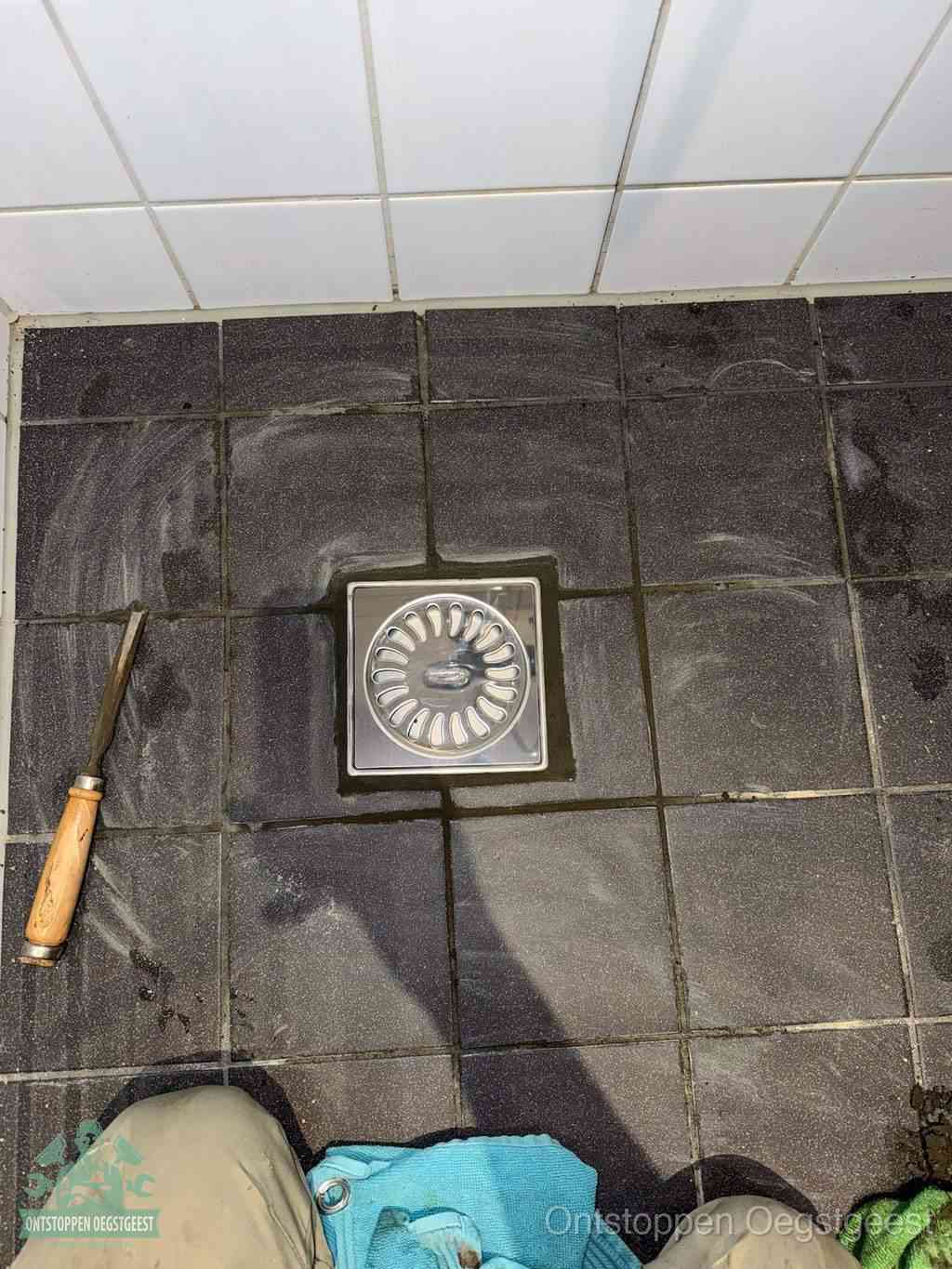 Een RVS doucheputje in een betegelde badkamervloer, zelf je badkamer ontstoppen in Oegstgeest