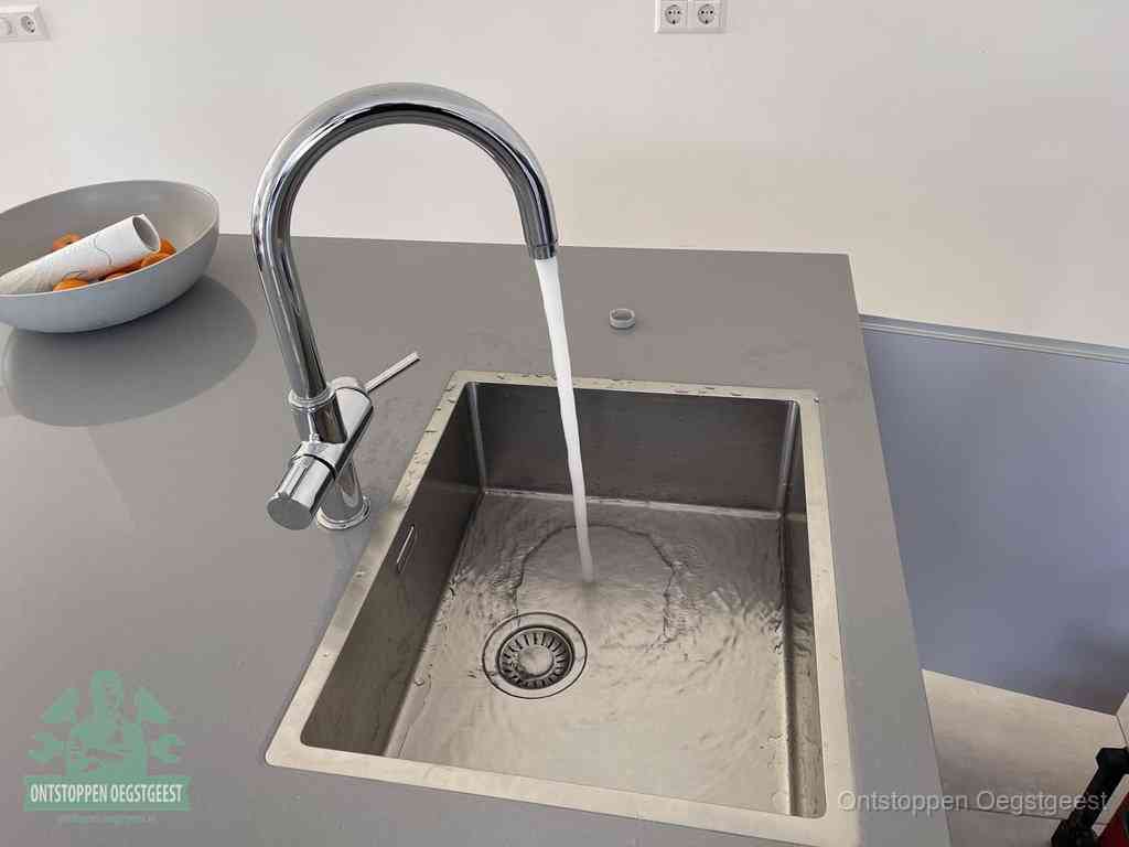 Een vrij doorstromende rvs spoelbak waar het water moeiteloos wegloopt, het resultaat van slim onderhoud dat geld bespaart in Oegstgeest