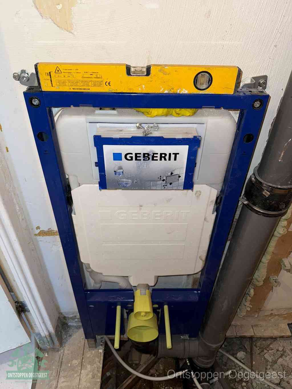Een Geberit inbouwreservoir met frame voor een hangtoilet tegen de wand, met de afvoerbocht naar de vloer, kenmerkend voor een verstopt hangtoilet in Oegstgeest