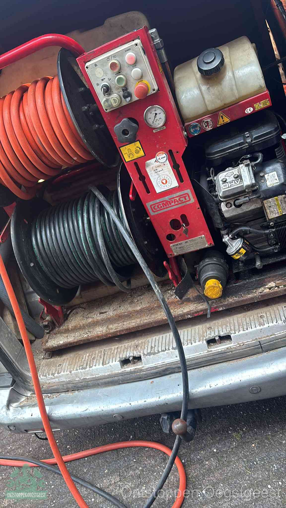 Een rood hogedruk-rioolreinigingstoestel met slangen in de laadbak van de bedrijfsbus, apparatuur voor een hardnekkige wc-verstopping in Oegstgeest