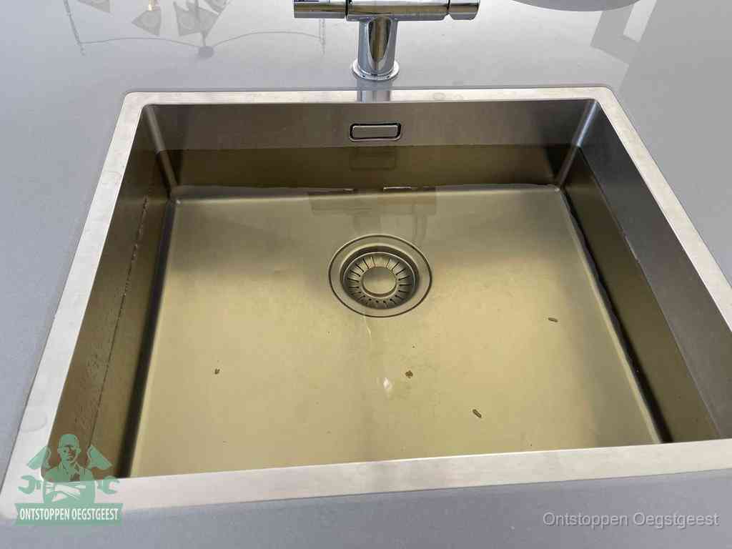 Een RVS spoelbak met stilstaand water dat niet wegloopt, een van de eerste signalen van een beginnende verstopping in Oegstgeest