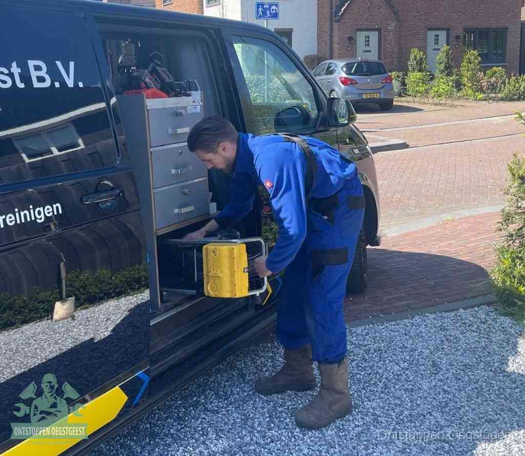 Een monteur pakt gereedschap uit de bedrijfsbus, het moment om een professionele ontstoppingsdienst in te schakelen in Oegstgeest