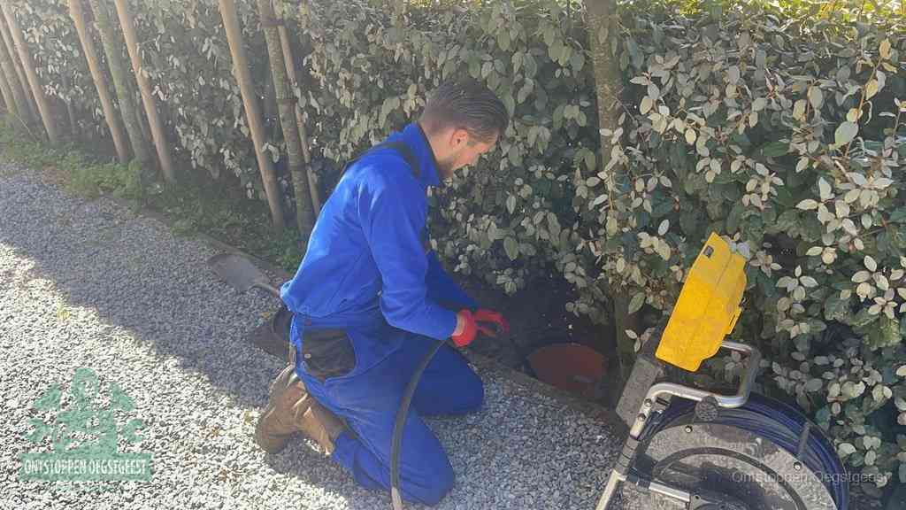 Monteur aan het werk bij een rioolput, de werkwijze voor riool ontstoppen in Oegstgeest