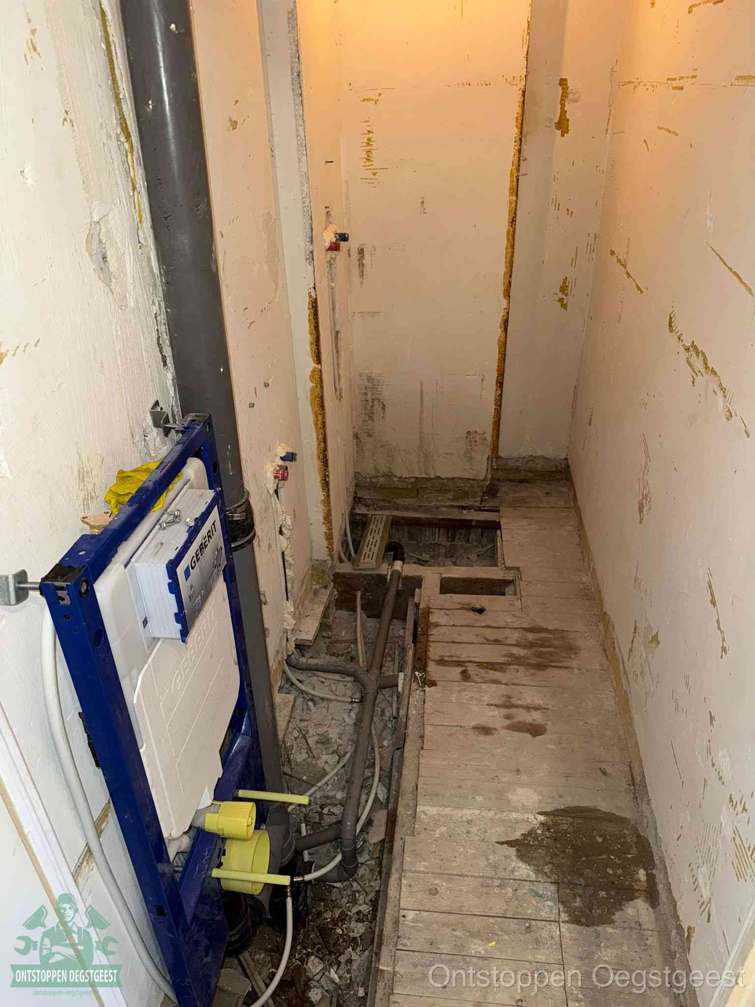 Een opgebroken toiletruimte tijdens renovatie met een Geberit inbouwreservoir en blootliggende oude afvoerleidingen, typisch voor oudere woningen in Oegstgeest
